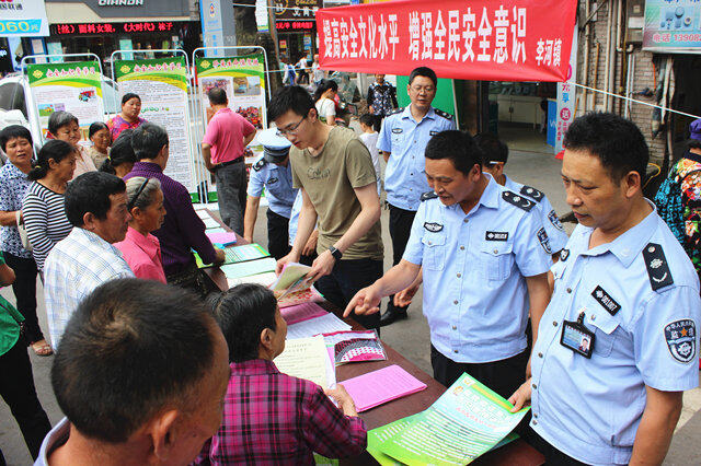 图为：农业执法人员向过往群众发放宣传资料